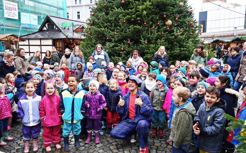 Vor dem geschmückten Tannenbaum.