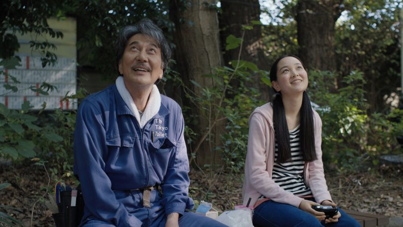 Hirayama (Koji Yakusho) und seine Nichte Niko (Arisa Nakano) bei der Mittagspause in einem kleinen Park.