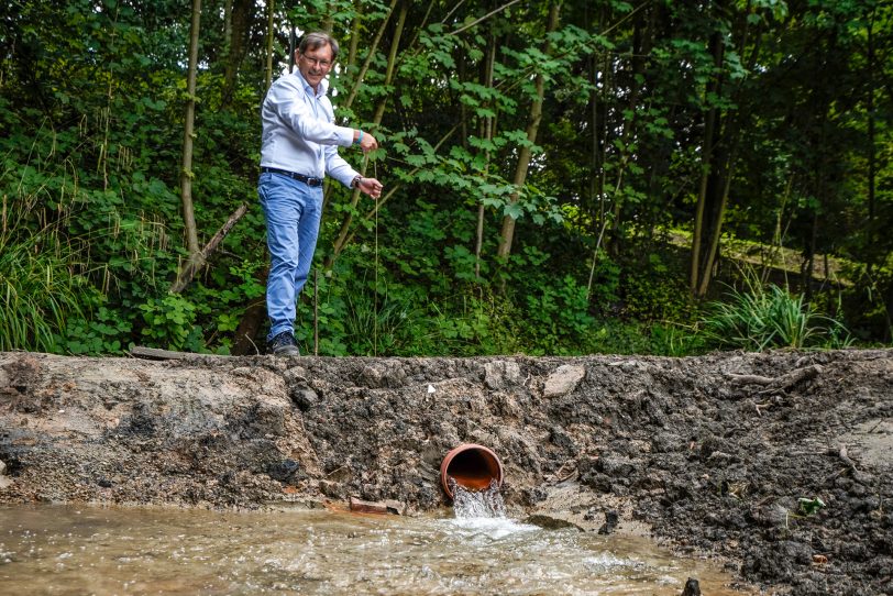 OB Dudda öffnet das Wasserrohr, damit der Ostbach ins neue Bett fließt.