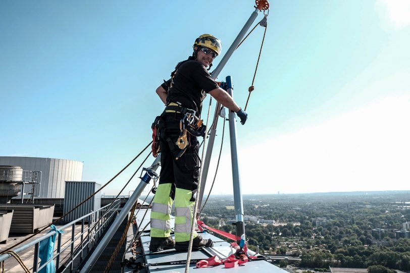 Industriekletterer bringen am Kesselhaus Block 4 der Steag AG in Baukau eine Werbetafel an.