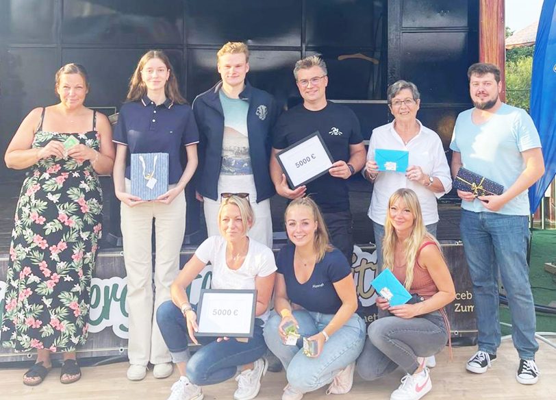 Christian Stoll vom Familiencircus Schnick-Schnack (stehend, 4. von li.) und Kristin Pfotenhauer von der JKD (knieend, li.) mit den Leo-Mitgliedern Cara Schirm, Michael Klein und Hannah Kolodziej sowie einigen der Gewinner bei der Preisübergabe 'Kirmeskalender' auf dem Kirmesplatz.