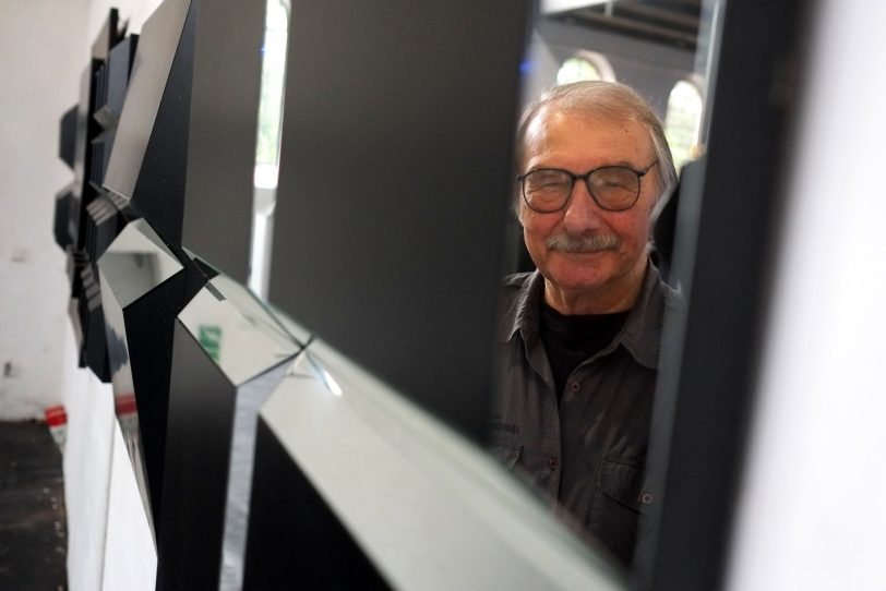 Künstler Helmut Bettenhausen neben einem seiner Werke.