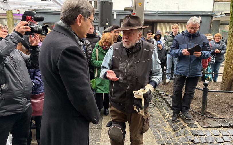 An der Hauptstraße 293 wurden am Mittwoch (28.1.2026) die ersten vier Stolpersteine für die Familie Hecht verlegt. Im Bild (li.) OB Dudda mit Künstler Gunter Demnig.
