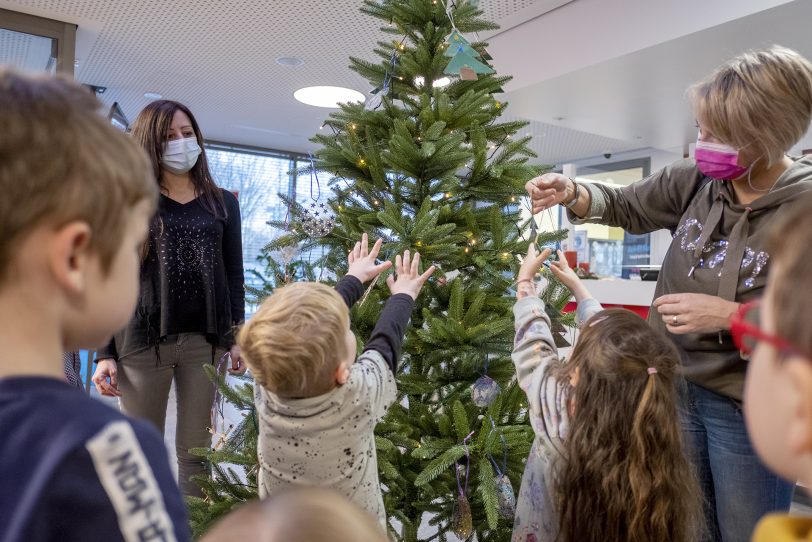 Tatkräftige Hilfe: Kinder der Kita Scharpwinkelring schmücken selbstgebasteltem Weihnachtsschmuck den Tannenbaum im Freizeitbad Wananas.