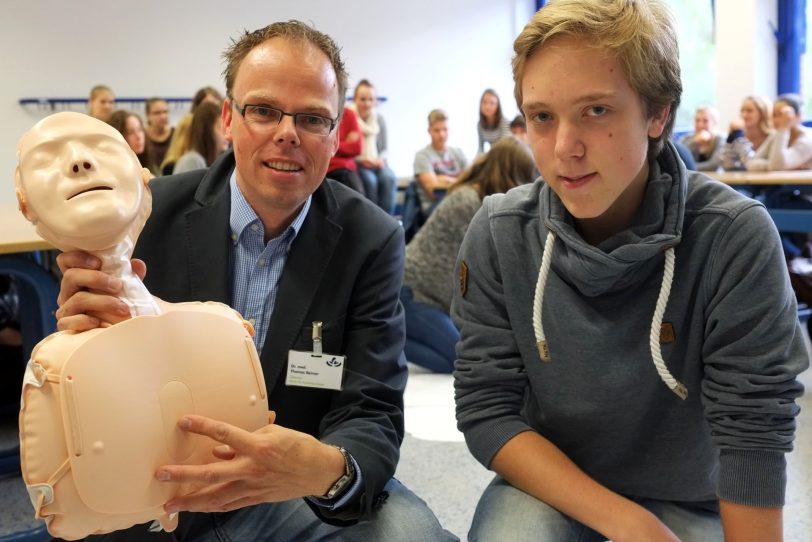 Dr. Thomas Reimer zeigt Maximilian die Stelle für die Herzdruck-Massage.