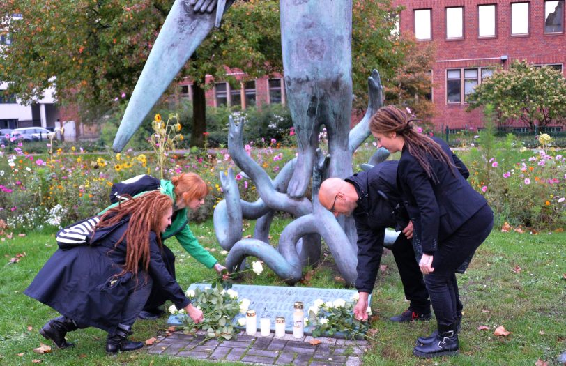 Grablichter und weiße Rosen am Mahnmal des Widerstandes.