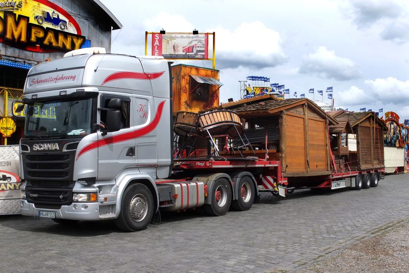 Nach der Rheinkirmes ist vor der Cranger Kirmes: Lkw beladen mit Häusern für das Almhüttendorf kommt am 21. Juli 2025 auf dem Platz in Crange an.