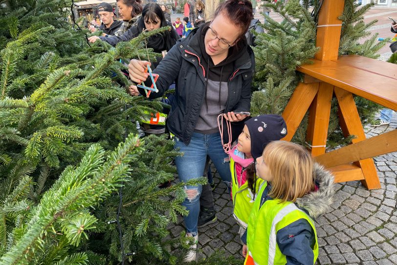 160 Kinder aus elf Kitas schmücken am Robert-Brauner-Platz mehrere Tannenbäume: Mit dabei war auch Elionor (vorne).