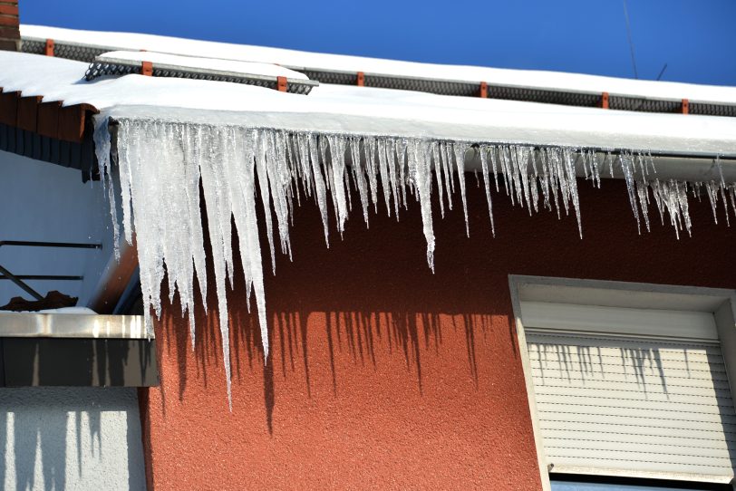 Eiszapfen und Schneebretter an Häusern können eine Gefahr für Passanten werden.