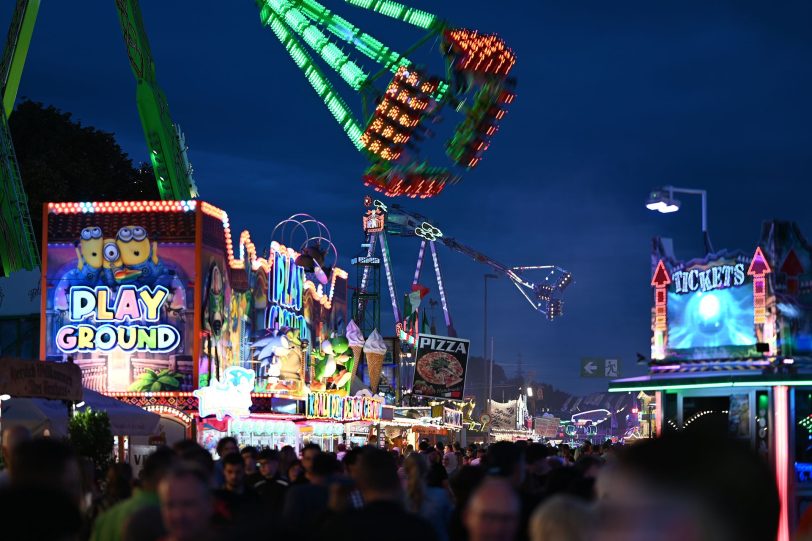 Der Cranger Kirmesplatz am Abend mit den Gondeln von Rundfahrbetrieb Konga und Hochfahrbetrieb Infinity . Riesenrad Jupiter, Kettenkarussel Wellenflug Blick auf die Cranger Kirmes von der Rathausstraße aus. Im Bild Riesenrad Jupiter, Hochfahrbetrieb Evolution sowie der Turm vom Hochfahrbetrieb Hangover The Tower