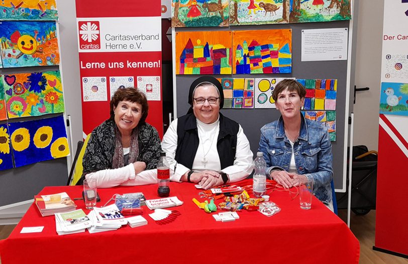 Umrahmt von bunten Werken aus dem Caritas-Kreativatelier (v. r. n. l.): Ulrike Lange und Sr. Veronika Walter (beide Caritasverband Herne) mit Kursleiterin Barbara Skratek.