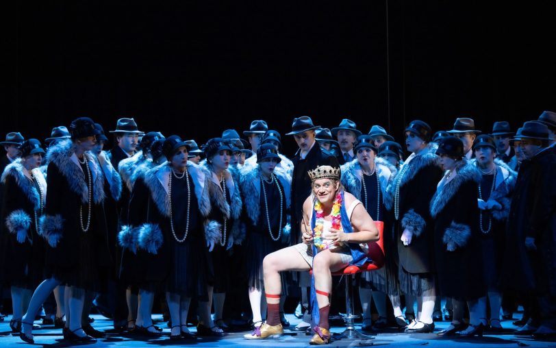 Cardillac (Heiko Trinsinger) überlebt als recht derangierter böser Clown, umringt von den grauen Gestalten des Volkes (Opernchor des Aalto-Theaters).