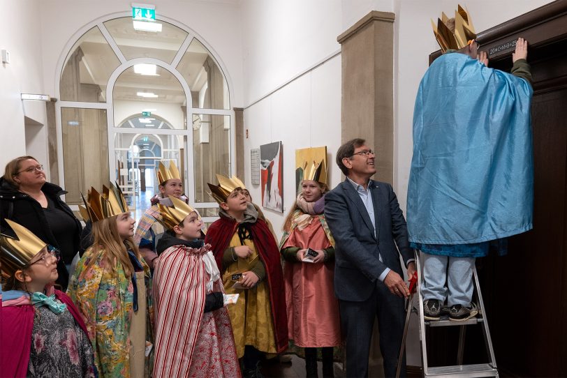 Sternsinger der Pfarrei Heilige Familie bringen den Segen über dem Dienstzimmer des Ob Dr. Dudda an.