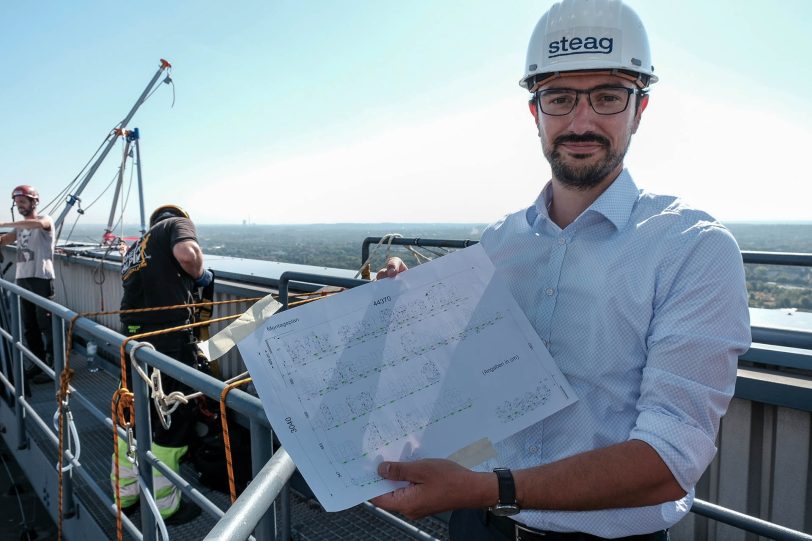 Industriekletterer bringen am Kesselhaus Block 4 der Steag AG in Baukau eine Werbetafel an.