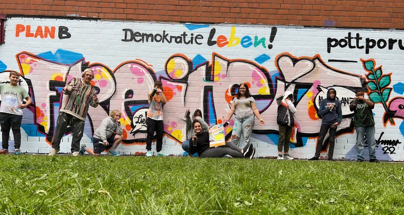 Die Teilnehmer vor ihrem Werk. Geleitet wurde der PLANB-Workshop von Graffiti-Künstler Patrick Brehmer (2. v. l.) und Berfin Güzel-Aksevi (PLANB, 5. v. l., vorn).