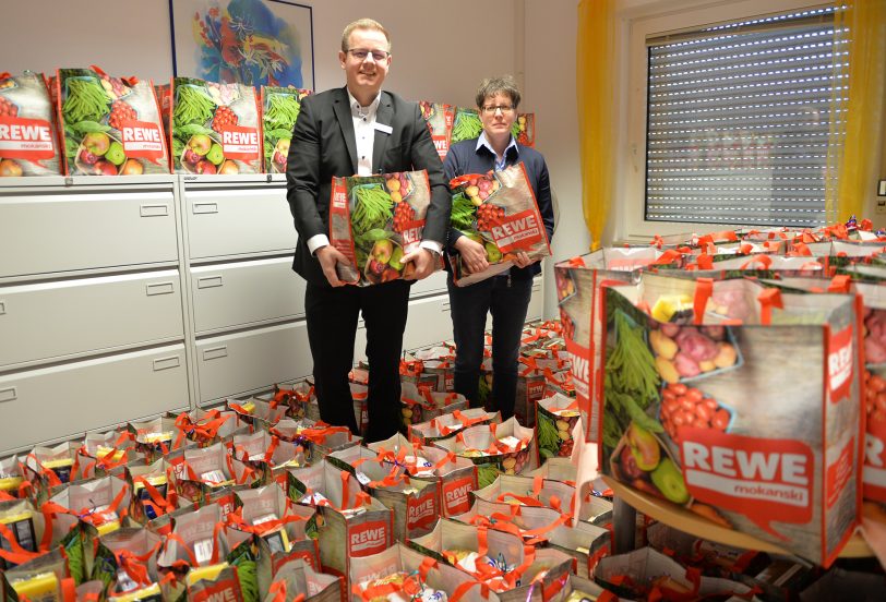 im Bild: Marc Plumpe von der Sparda Bank, dem größten Sponsor der Aktion, und Susanne Queens von der Schuldnerberatung, die die 180 Taschen gepackt hat.