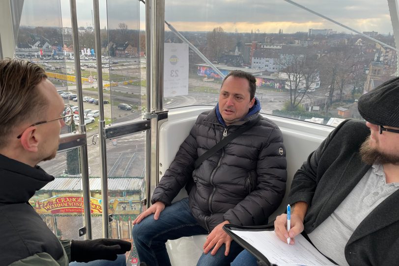 Job-Speeddating in der Riesenrad-Gondel auf dem Cranger Weihnachtszauber in luftiger Höhe: (v.li.) Sadik Hasanic (Tedi Betriebsleiter für Herne und Bochum), Bewerber Antonio Dicarlo und Joshua Korzeniowsky (angehender Betriebsleiter bei Tedi).