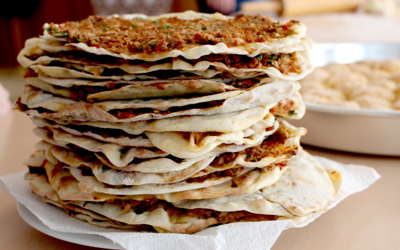 Lahmacun ist ein Fladenbrot aus Hefeteig, mit einer Mischung aus Hackfleisch, Zwiebeln und Tomaten bestrichen.