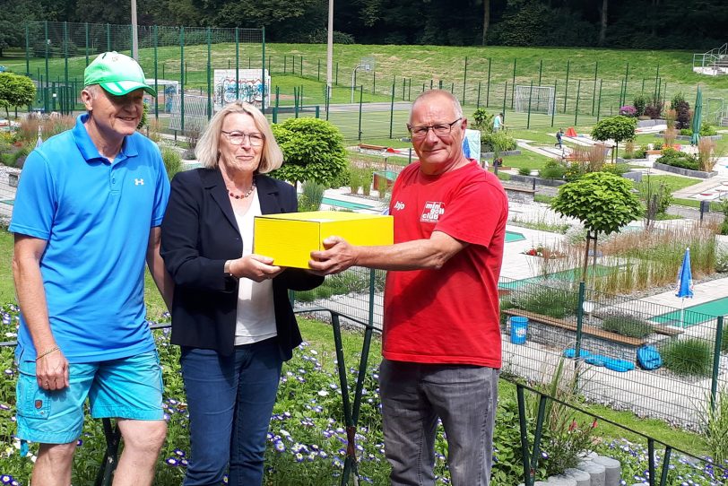 Vizepräsidentin Mitarbeiter-Entwicklung und Gleichstellung des Landessportbundes NRW Mona Küppers überreicht MGC Sportwart Joachim Garden ein Präsentpaket.