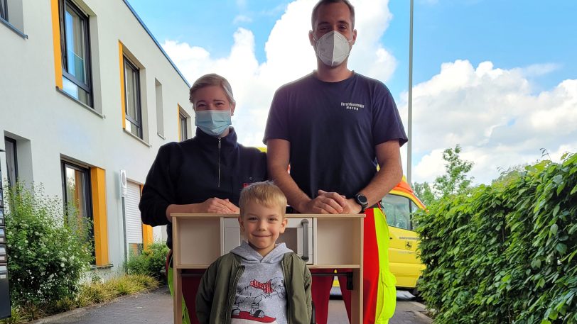 Notfallsanitäterin Vanessa und Rettungssanitäter Timo überreichten an Joel (6) die neue Spielküche.