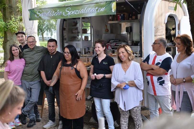 'Team Olli' und die 'Sardischen Schwestern – Sorelle Sarde' begrüßen ihre Gäste zum ersten Sardischen Abend' im Biergarten von Ollis Restaurant.