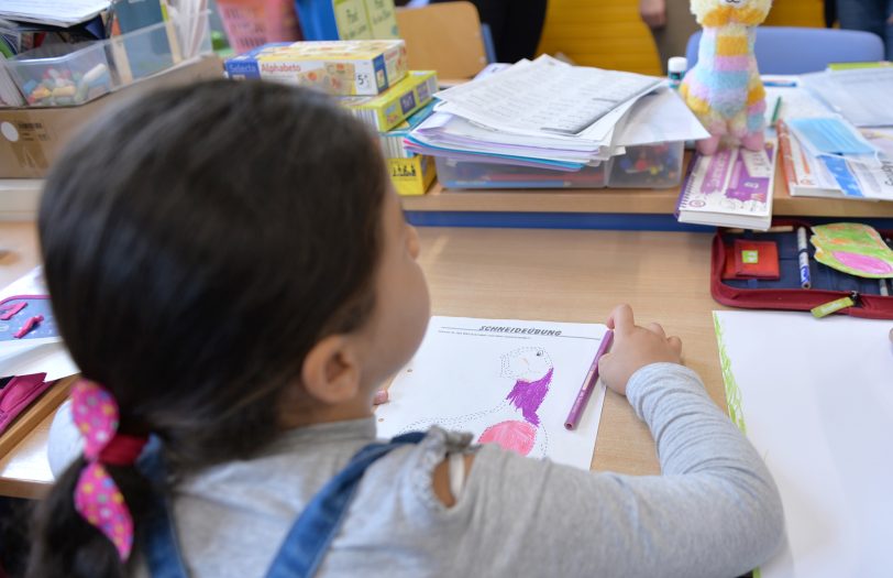 Kinder malen, lesen, rechnen während der Sommerferien mit Eifer.