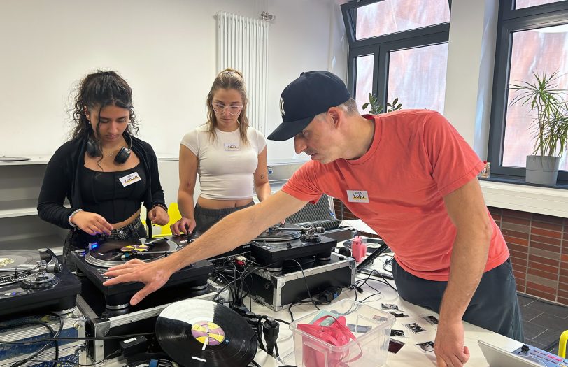 Kolja Vorthmann (r.) zeigt Zahara (li.). und Laura wichtige Handgriffe beim DJing.