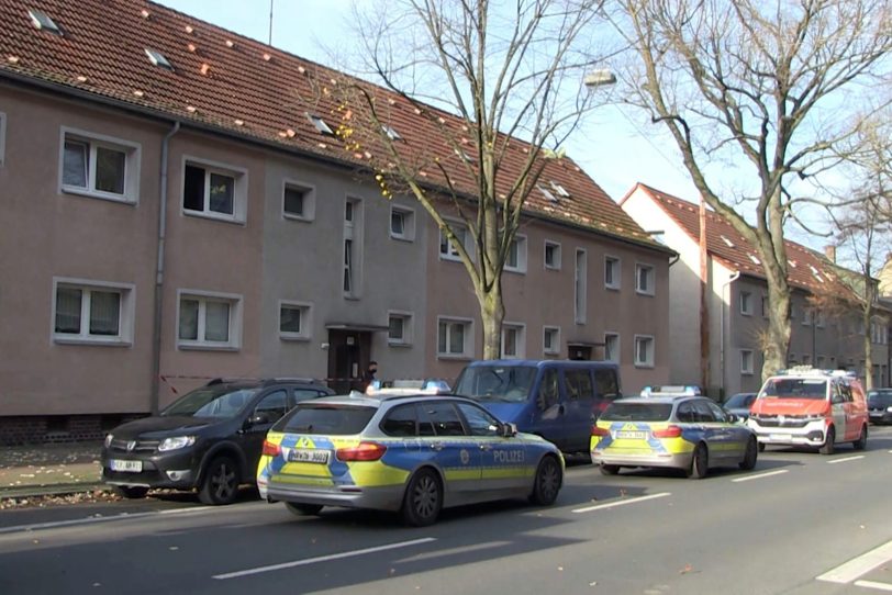 Polizeiwagen stehen vor einem Mehrfamilienhaus an der Bahnhofstraße.