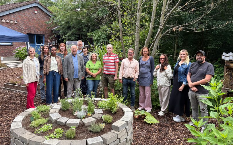 Gruppenbild am runden Steinhochbeet: Einige der Verantwortlichen und Sponsoren sowie Katja Grewe (2.v.r.), stellvertretende Kitaleiterin und Lea Blumenkemper (7.v.l.), Lehrerin der EFG und der stellvertretende Bezirksbürgermeister von Herne-Mitte, Karl Josef Schleußner (5.v.l.).