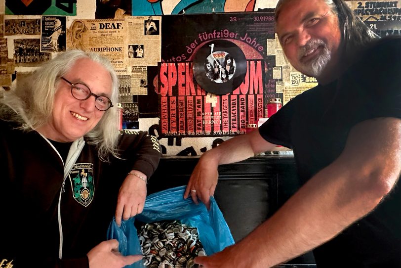 Arnd Spiering (re.), erster Vorsitzender des Stennert Musiker-Treff, übergibt einen ganzen Sack voller Kronkorken an Horst 