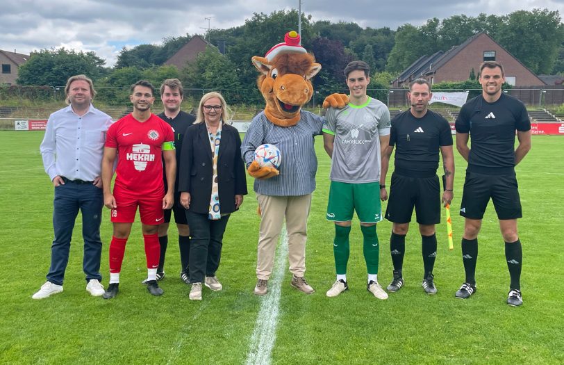 Kirmespferd Fritz (Mitte) führte gemeinsam mit Hernes Bürgermeisterin Andrea Oehler (4.li.) beim Eröffnungsspiel den Anstoß aus. Beobachtet wurden sie dabei von den Kapitänen Hakan Oeztürk (Wanne 11, 2. li.) und Moritz Felber (SVS,6.li.), dem stellv. SVS-Vorsitzenden Eduard „Edy“ Weidenbach (1.li.) sowie dem Schiedsrichter-Gespann um Niklas Simpson (re.).