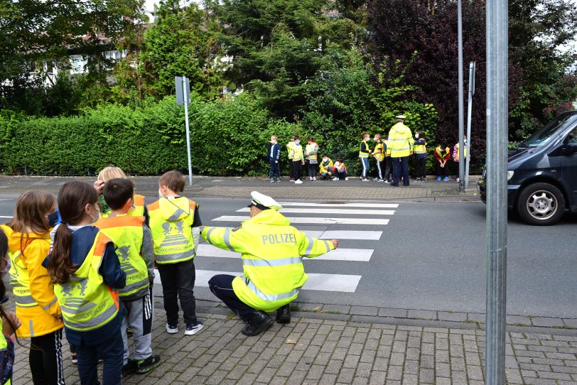 Schulanfangsaktion 2021 an der Sonnenschule. Mit den Bezirksbeamten wird die Straße überquert.