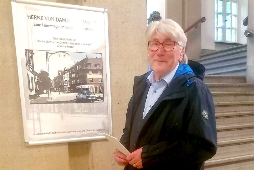 Uli Folta vor dem Plakat zur Ausstellung von Gerd Biedermann.