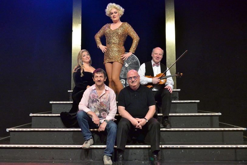 Jeanny im Glitzerkleid mit Backgroundsängerin Angela Agro, Musiker Dieter Orzschig (Mitte), Autor Sigi Domke und Prinzipal Christian Stratmann (Unten).