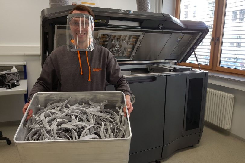 Schutzmasken aus dem 3D-Drucker: Der wissenschaftliche Mitarbeiter Matthias Krause demonstriert, wie die komplette Haube nach dem Zusammenbau in den Kliniken aussehen wird.