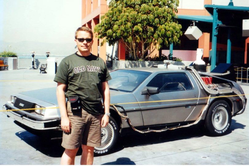 halloherne Reporter Patrick Mammen (2002) vor dem DeLorean aus Back to the Future in den Universal Studios, Los Angeles.
