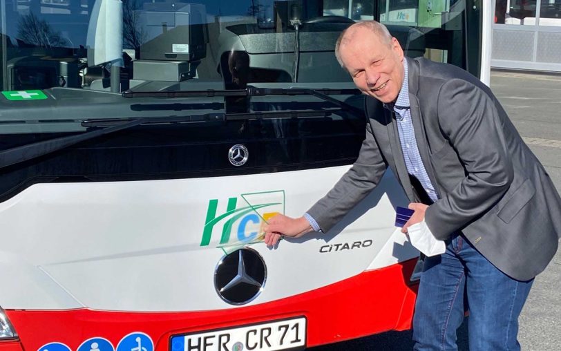 HCR-Geschäftsführer Karsten Krüger klebt ein neues Logo auf einen der 73 HCR-Busse.