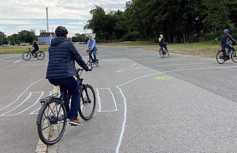 Mitarbeiter der Verkehrswacht und des Tiefbauamtes testen die aufgemalte Verkehrsführung der neuen Jugendverkehrsschule auf dem Cranger Kirmes Platz.