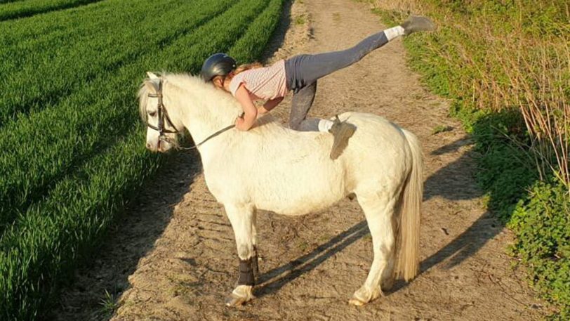 Gelenkig auf dem Pferd ist diese Tänzerin.