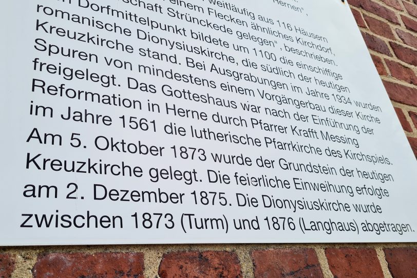 Die Infotafel mit den geschichtlichen Daten an der Kirchenfassade.