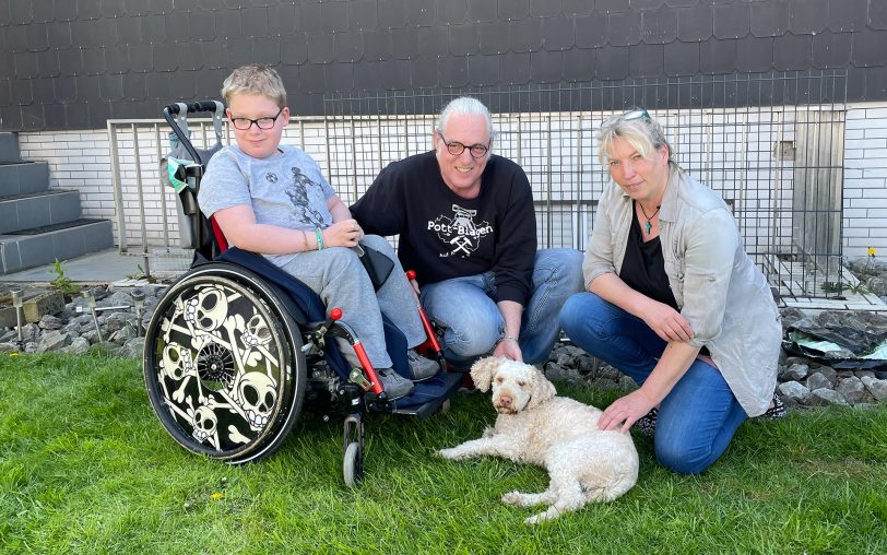 v.l. Daimon mit Horst Schröder und Tierpsychologin Regina Thorlümke. Hündin Amy liegt im Gras.