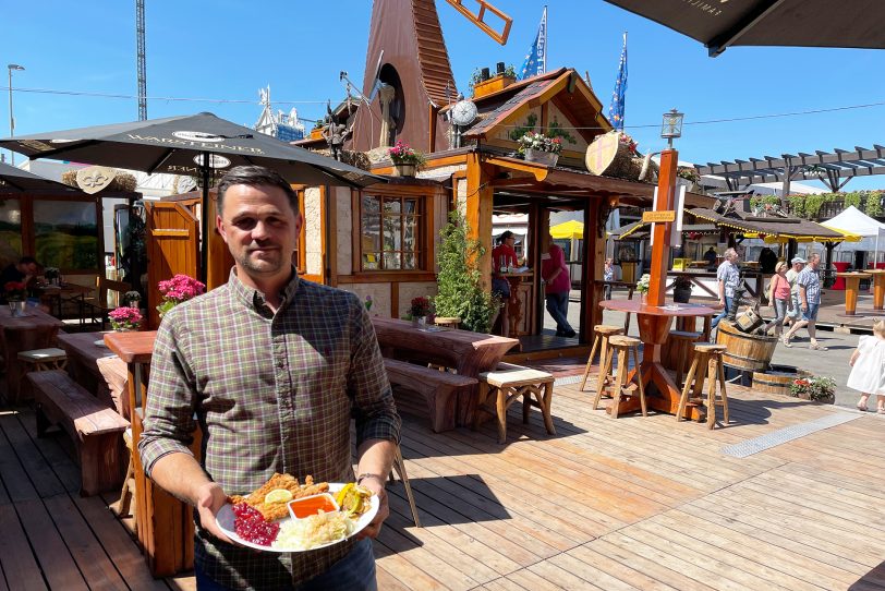 Jeffrey Bauer präsentiert einen Schnitzelteller mit Krautsalat und Bratkartoffeln.