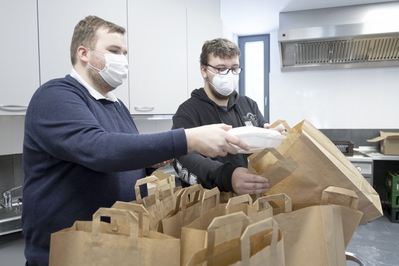 Holger Spies (li.) und Leon Brandt packen in der Küche die Tüten.