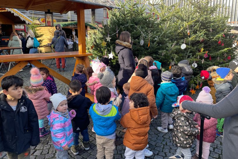 160 Kinder aus elf Kitas schmücken am Robert-Brauner-Platz am Freitag (25.11.2022) mehrere Tannenbäume.