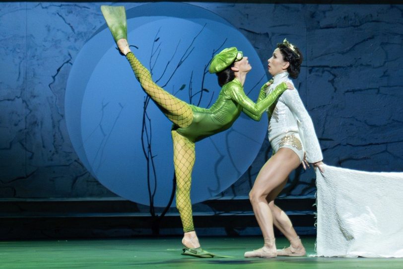 In Bridget Breiners auf ganz eigene Weise großartiger „Dornröschen“-Choreographie eröffnet die Weise Frau Carabosse im Froschkostüm (Sophie Martin) der gerade badenden Königin (Balkiya Zhanburchinova), dass sie nach langen Jahren des Hoffens ein Kind gebären wird.