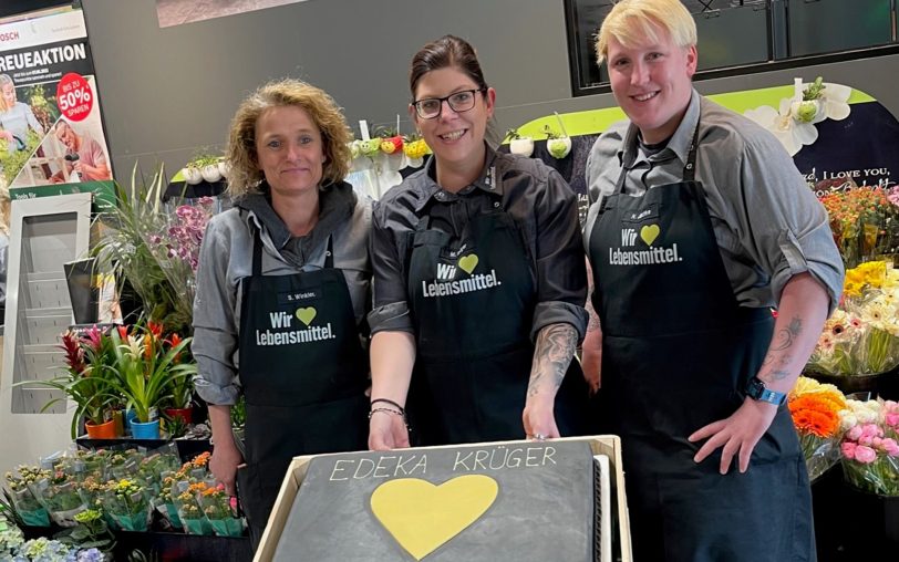 Ein Jahr Edeka Krüger nach der Wiedereröffnung wird mit einer Torte gefeiert: (v.li.) Sandra Winkler, Chefin Melanie Krüger und Nina Jäschke.