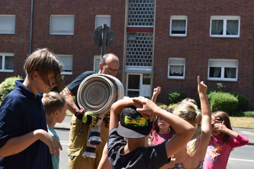 halloherne-Fotograf und freiwilliger Feuerwehrmann, Stefan Kuhn, leistet mit einem Feuerwehrwagen und ganz viel Wasser 'Nachbarschaftshilfe'. Die Armaturen im neuen Stadtteilzentrum H2Ö sind so modern, dass sie keine Wasserbomben befüllen können. Also kam Stefan mit ganz viiiel Wasser: Wasserschlacht gerettet.