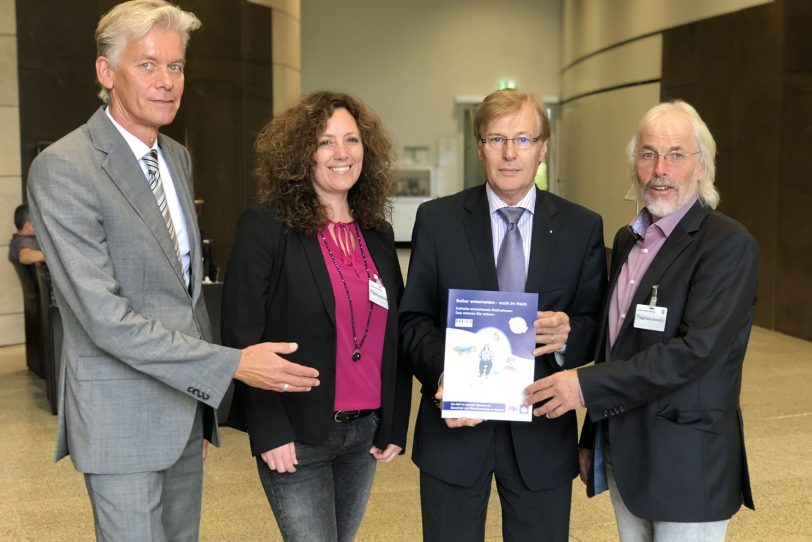 v.l. Georg Dodegge, Karin Wallbaum, Lothar Buddinger (alle Überörtliche AG für das Betreuungswesen) überreichen NRW-Justizminister Peter Biesenbach die neuen Broschüren.