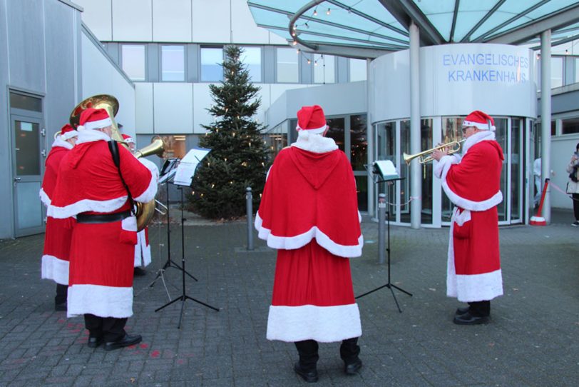 Als Weihnachtsmänner verkleidete Bläser erfreuen Patienten und Mitarbeitende des EvK Herne.