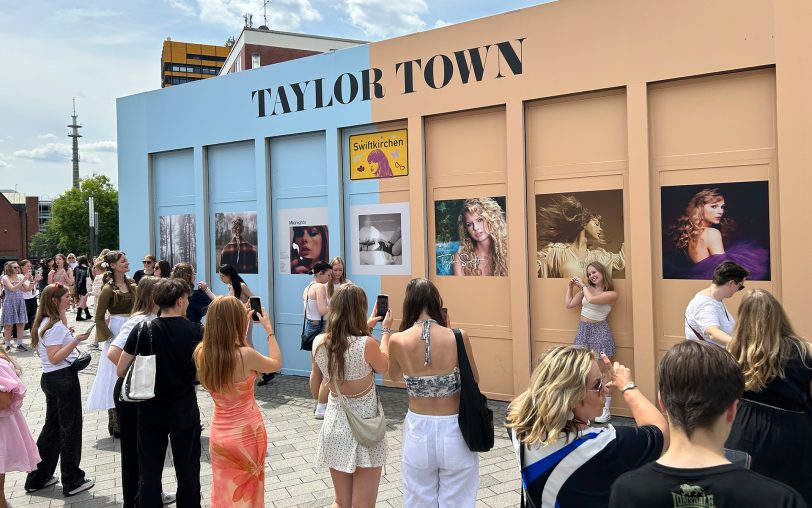 In Gelsenkirchen ist am Heinrich-König-Platz das Warm Up für das dritte Taylor Swift Konzert in der Arena Auf Schalke. Hunderte Swifties stimmen sich auf das Konzert ein und machen Fotos, STEEL legt Musik auf.